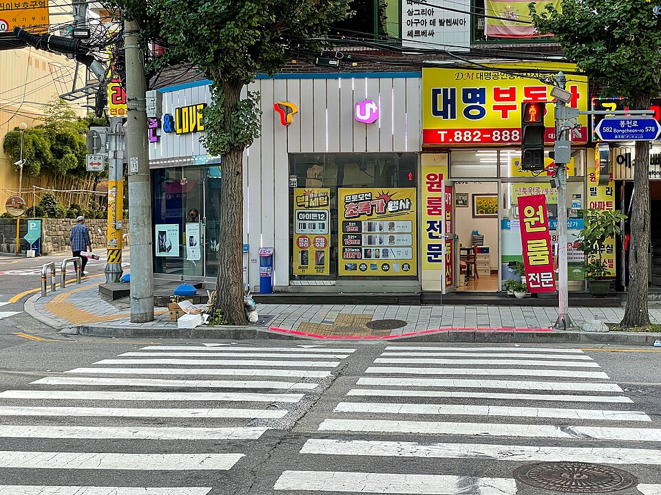 한국 교차로 횡단보도 앞의 보행자 신호와 바닥 신호등이 빨간색으로 켜진 모습